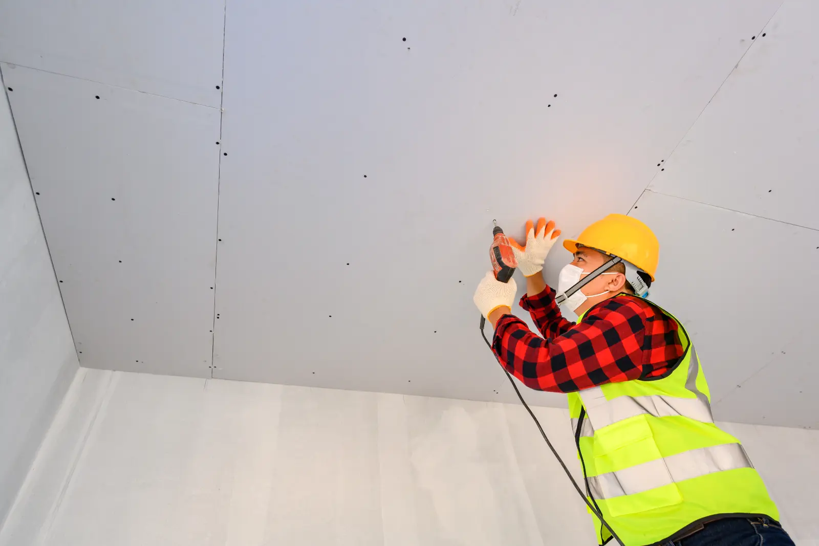 Plasterboard Repair. Drill home ceiling Construction workers assemble the ceiling with drywall