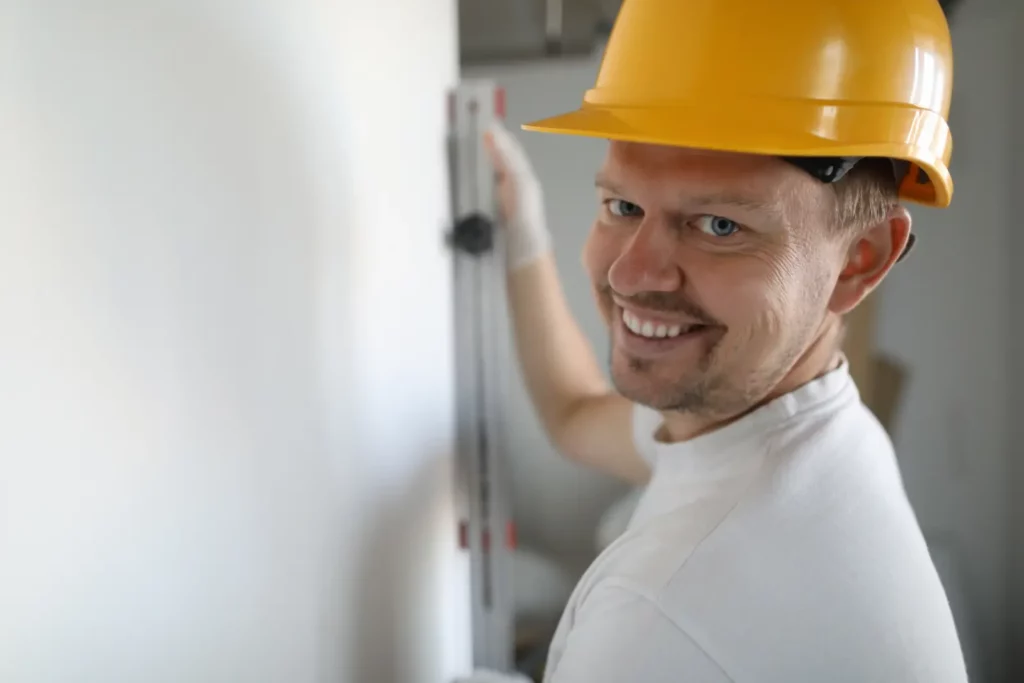 Common Drywall . Smiling worker wearing helmet