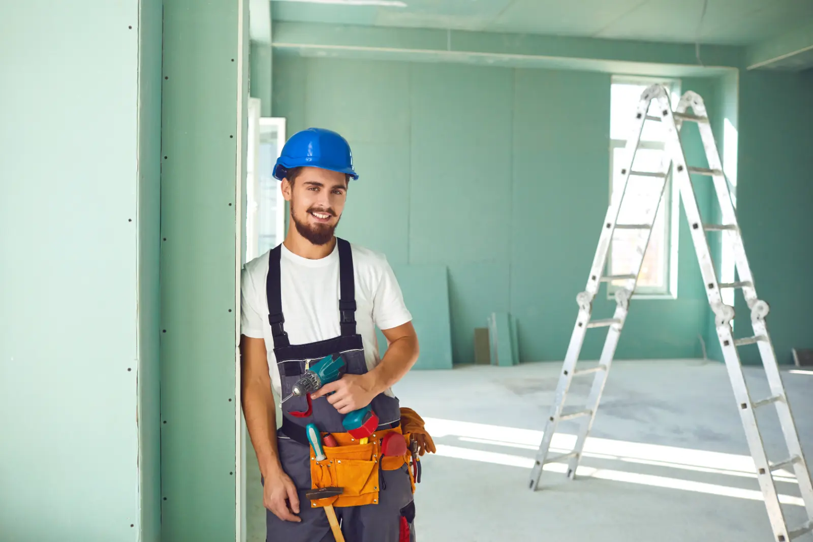 Drywall Installation Techniques. builder installs plasterboard drywall at a construction